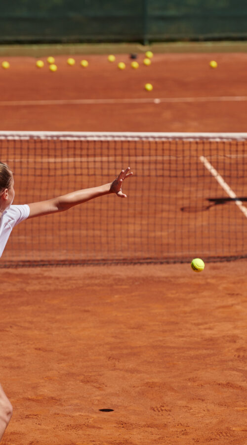 A professional tennis player and her coach training on a sunny day at the tennis court. Training and preparation of a professional tennis player.