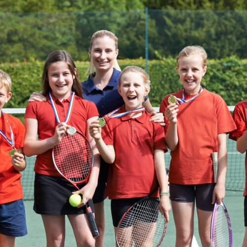 Portrait Of Winning School Tennis Team With Medals